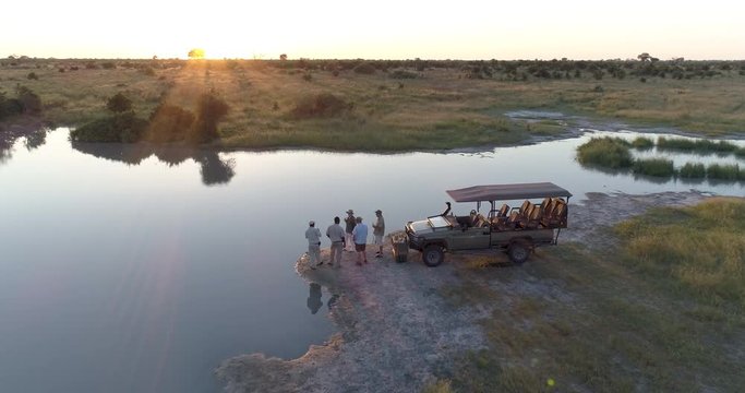 Aerial view of Tourists and guides enjoying a sundowner at the rivers edge in the Okavango  Delta at sunset
