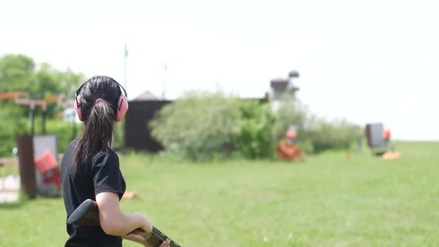 young beautiful girl shoots a flying target at an open shooting range,trap shooting