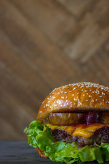 Homemade burger with pear and cherry on the wooden table. Half view with empty space for text