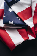 folded american national flag isolated on black, memorial day concept