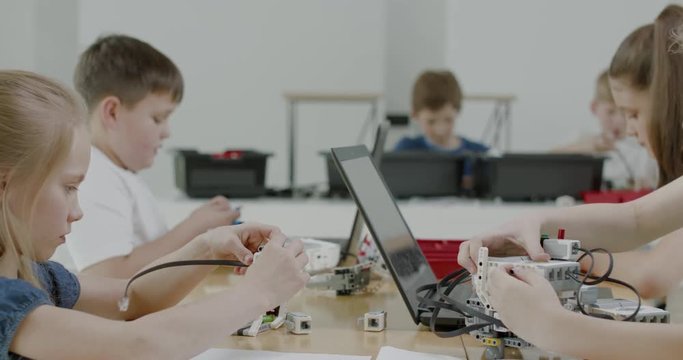 Curious kids working on a functional programable robot during robotics class at school. 4K UHD 60 FPS SLOW MOTION