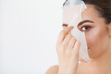 Skin Care. Young Female Removing Mask From Facial Skin. Woman Beauty Face