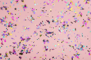 Top view of colorful confetti on pink party background