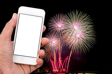 Hand holding mobile smart phone with blank screen in vertical position, fireworks background - mockup template