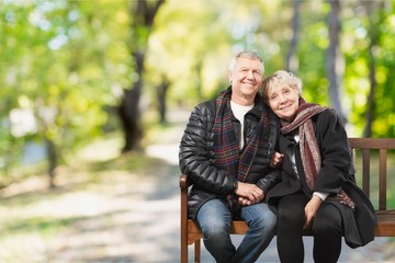 Close-up portrait of an elderly couple hugging in park
