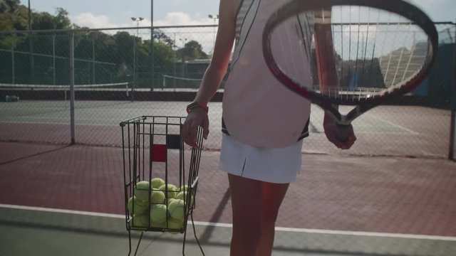 Anonymous tennis player bouncing ball on court