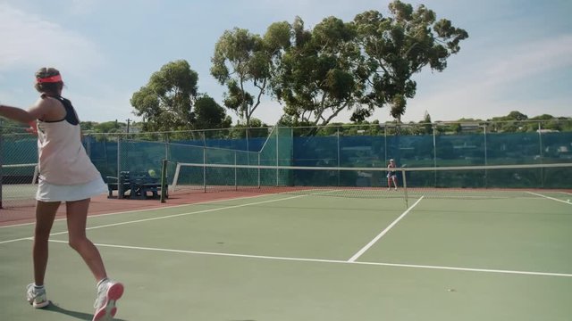 Tween girls having a rally playing tennis