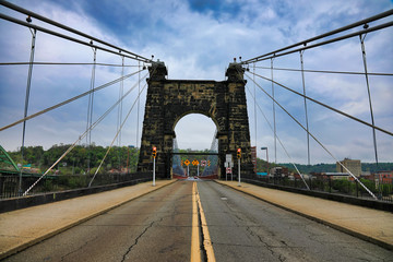 The Wheeling Suspension bridge is a historic landmark that spans the Ohio river into Wheeling , West Virginia.
