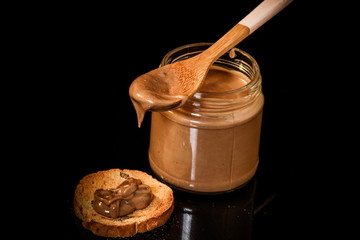 closeup chocolate peanut butter in glass jar and small cracker