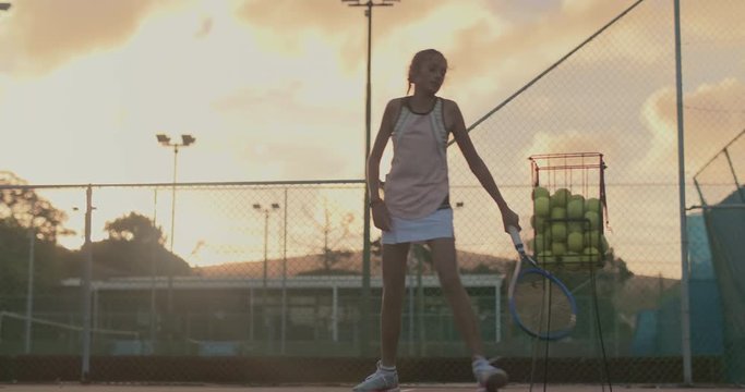 Lonely tennis player practising hard into the night