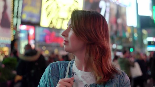 Times square at night. Young woman walking