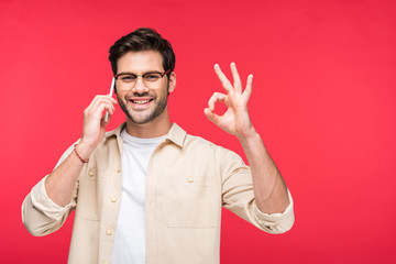 happy man talking on smartphone and doing OK Sign Isolated On pink