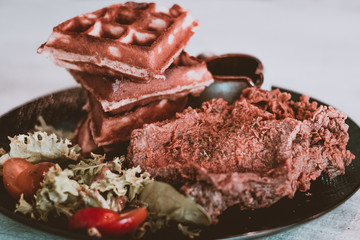 Chef signature crispy chicken served on homemade waffles with maple syrup