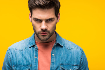 Obraz premium handsome aggressive man looking at camera Isolated On yellow