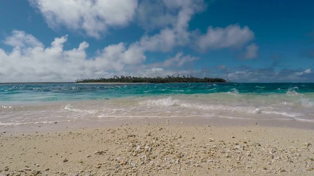View of Foa Island and crystalline sea from white sand beach in Tonga