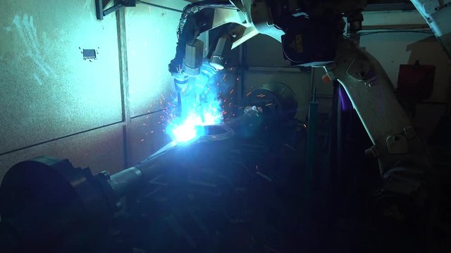 Team industrial robot are movement welding automotive part in factory