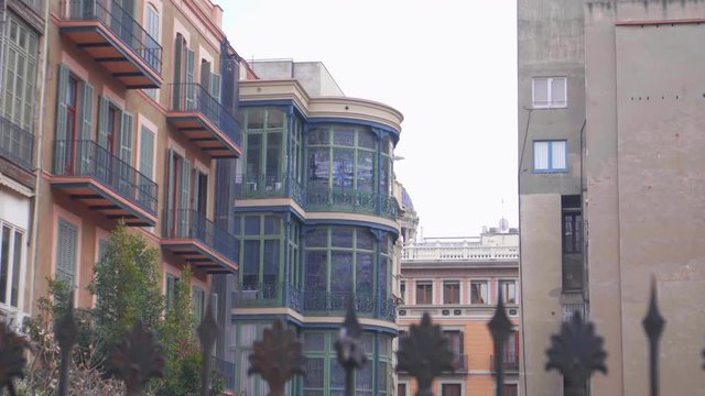 Beautiful neigbouring house with huge tinted glass windows behind iron fence near Casa Batllo in Barcelona in January