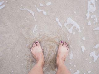 Selfie woman feet on summer beach background.