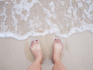 Selfie woman feet on summer beach background.