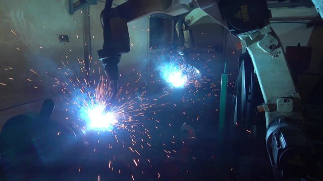 Team industrial robot are movement welding automotive part in factory