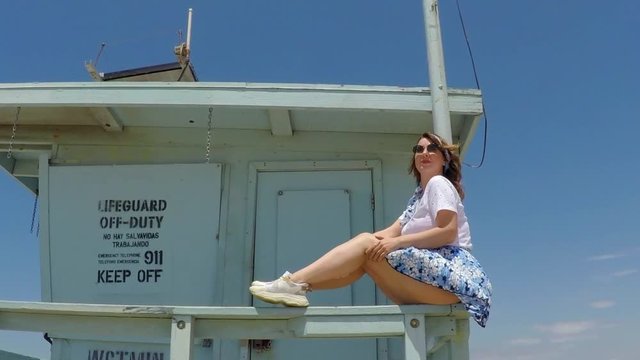 Young girl at the beach. Lifeguard booth