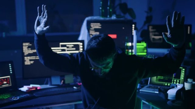 Highly wanted computer hacker caught by the policeman at cyber crime. Man putting hands behind his back with head bowed.