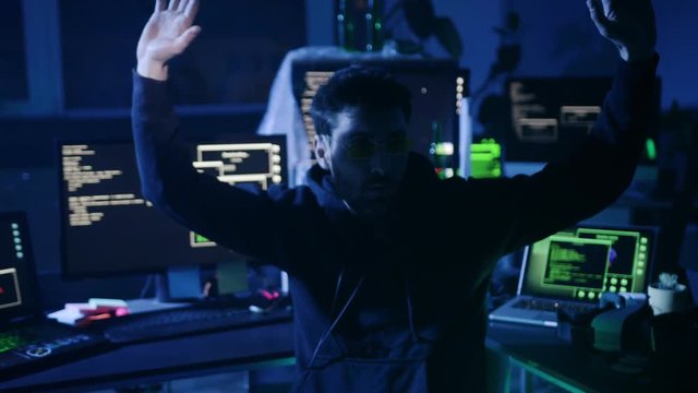 Startled computer hacker caught and arrested for breaking into security system. Act of internet and cyber crime at night.