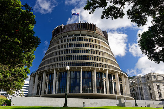Fototapeta The Beehive, New Zealand's parliament building with the New Zealand flag flying against a blue sky
