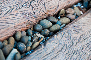 Pebble Stone in the middle of wood path way exterior garden landscape architecture close up horizontal with shade shadow from the leaves of sun light