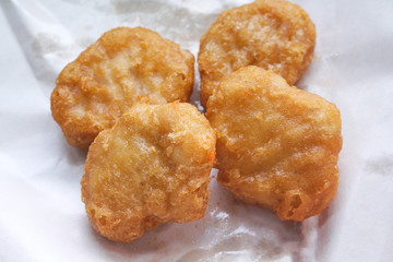 Chicken nuggets on white blotting paper oil background