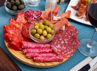 Slices of gammon, sausages on wooden board