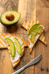 toasts with avocado, on wooden background, delicious breakfast