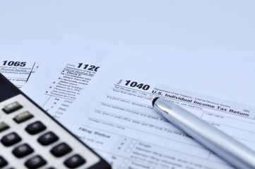Tax Season: 1040 U.S. Individual Income Tax Return Form Horizontal top right view of an office laptop background with a metallic pen preparation on taxation.