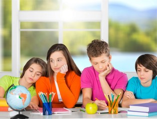 Friendly school children on blurred classroom background