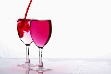 Red food coloring diffuse in water inside wine glass