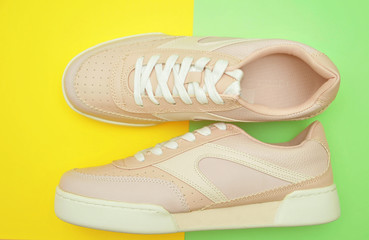 Stylish pink shoes on pastel color background.
