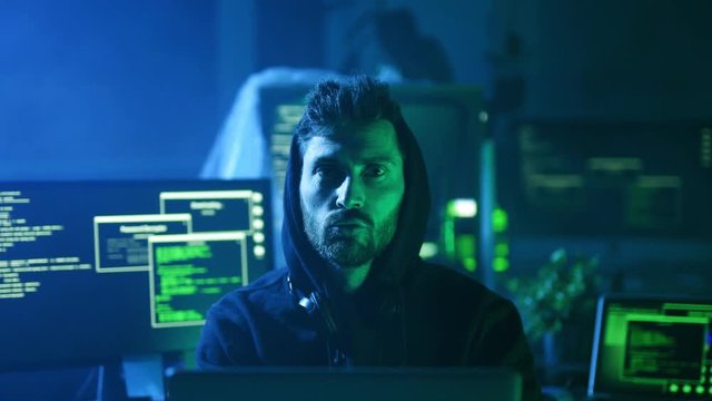 Portrait of cheerful coquettish programmer inflating his lips flirting at camera at desk. Handsome funny guy working on computer in the office.