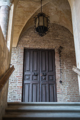 Antique Wooden Door with Antique Metal Chandelier in Fontanellato in Parma, Italy