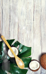 Coconut oil and flakes, tropical leaves and fresh coconuts