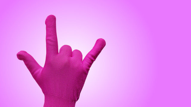 Hand Gesturing in Pink Glove as I Love You Isolated on Gradient Pink Background