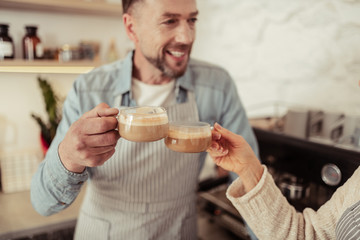 Happy couple clanging glasses of coffee together.