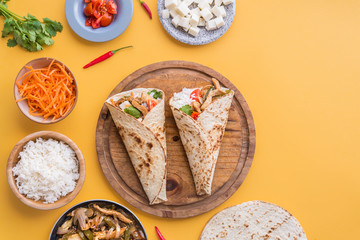 Fajitas and ingredients top view and yellow background