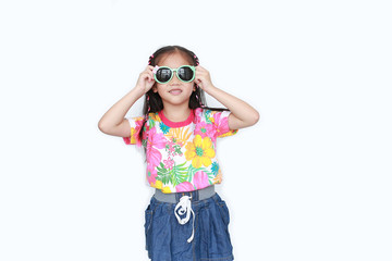 Smiling little Asian child girl wearing a floral pattern summer dress and sunglasses isolated on white background. Summer and fashion concept.