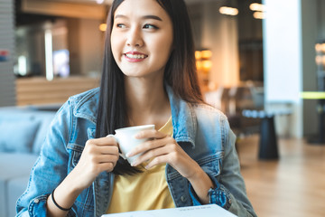 Asian woman in a cafe drinking coffee .Portrait of Asian woman smiling in coffee shop cafe vintage color tone.