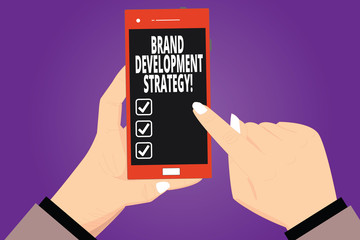 Text sign showing Brand Development Strategy. Conceptual photo analysis and planning of brand perceive in market Hu analysis Hands Holding Pointing Touching Smartphone Blank Color Screen