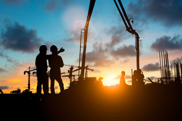 Silhouette of engineer and construction team working at site over blurred background for industry...