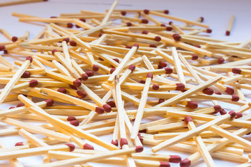 Close-up of wooden matches in a pile lying on a table with a brown sulfur head. Symbol of flammability and fire. Household object for kindling fire.