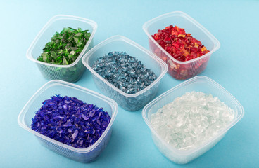 Broken glass sorted by color in plastic package. Recycling glass waste for creativity and crafts. Raw materials for handmade.