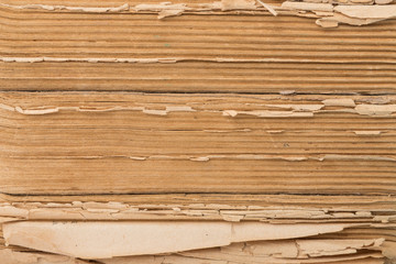 Close-up view of a stack of old, ancient books with torn yellow pages.