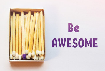 White matches and one match of purple color in a box. Difference, self respect and acceptance concept. Motivational phrase on the image. Opposition, uniqueness, diversity concept. Not like others.